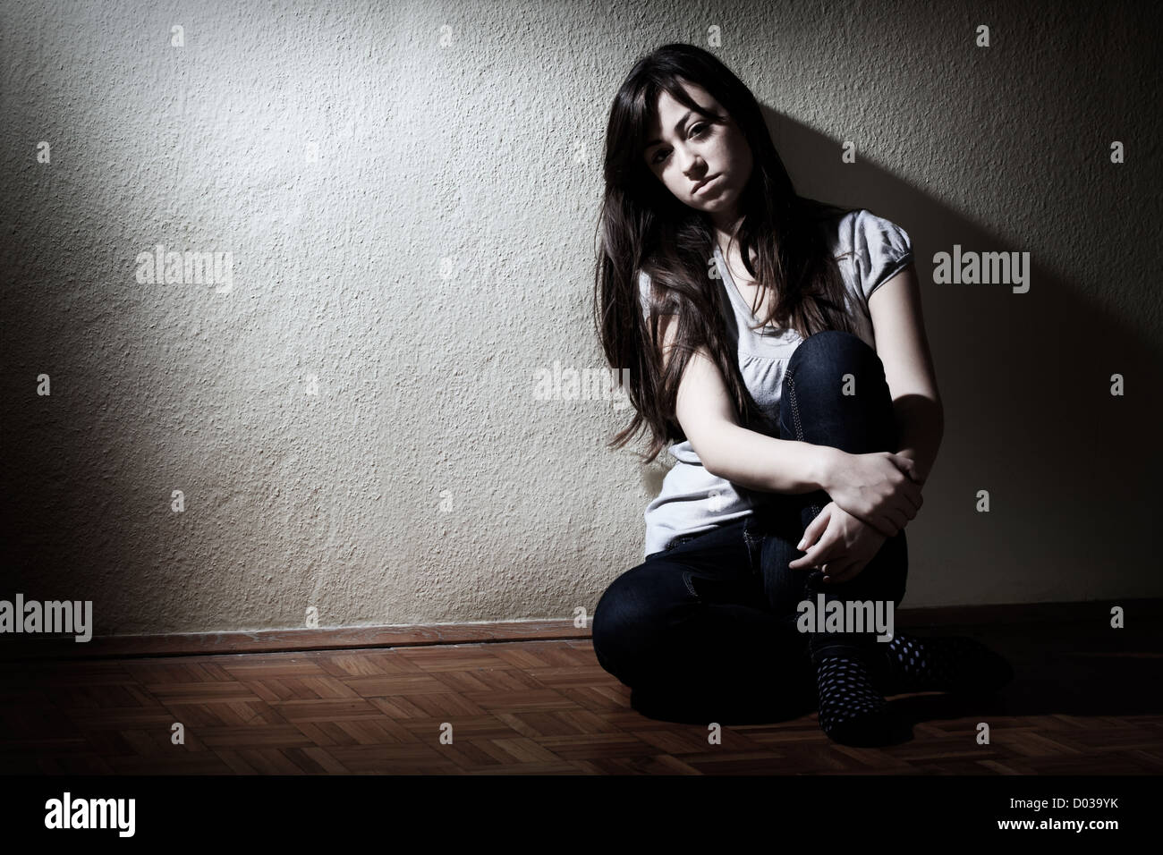 Depressed teenager girl sitting on floor Stock Photo - Alamy