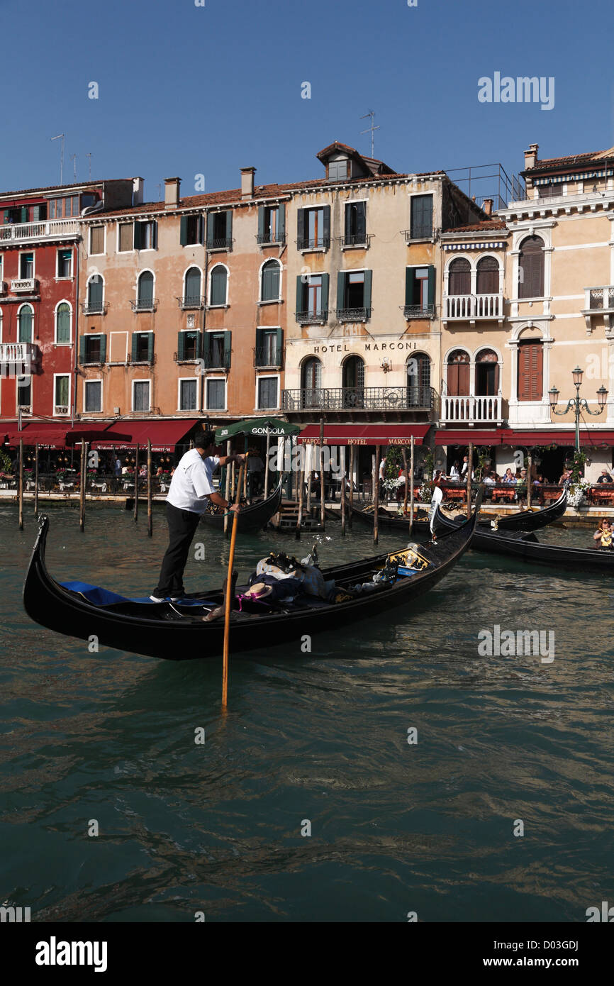 Gondolas and gondoliers on the Grand Canal Restaurants overlooking the Rialto Bridge Venice Italy in Autumn Stock Photo