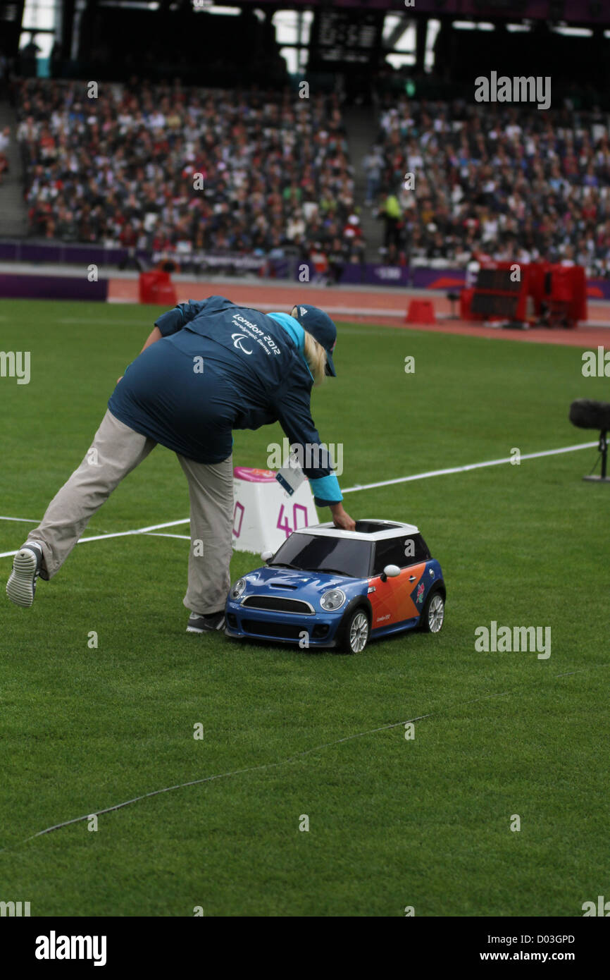 Umpire puts discus in the remote controlled mini car in the Men's Discus Throw F42 at the
