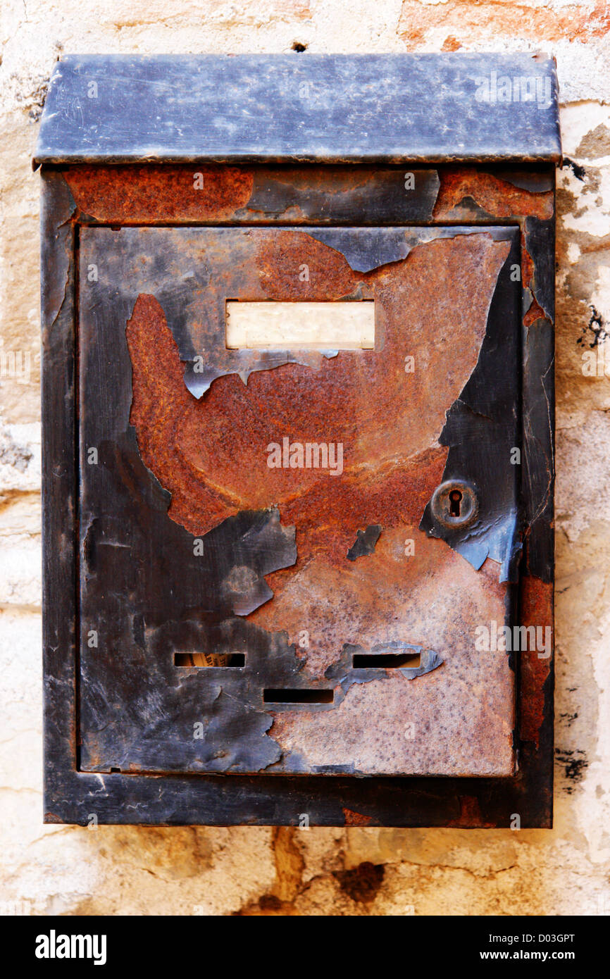 Old rusty mailbox on the shabby gate in Italy Stock Photo