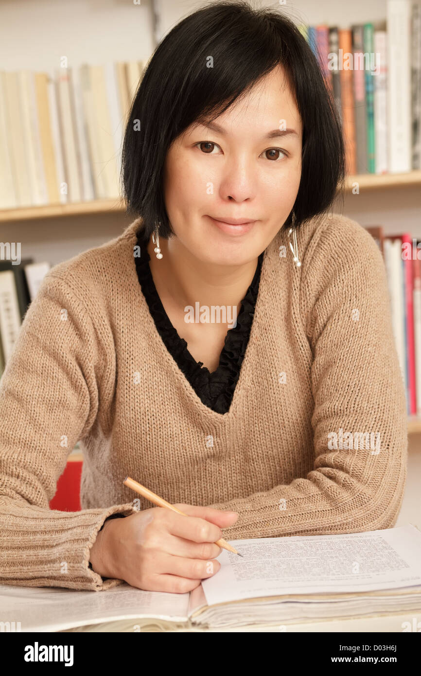 Asian woman working at home with smiling expression on face. Stock Photo