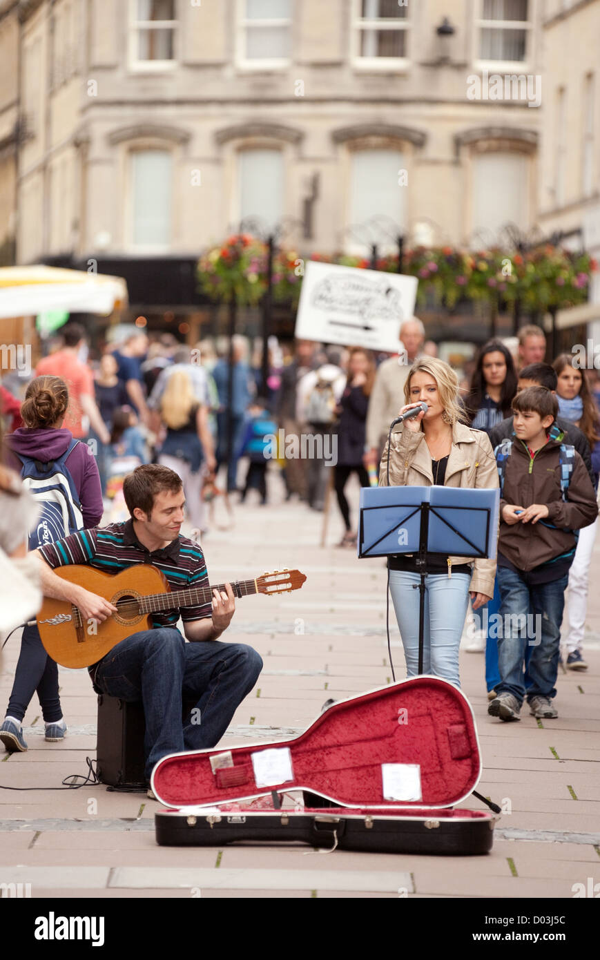 Street performers - A guitar player and singer performing on the streets of bath Somerset UK Stock Photo