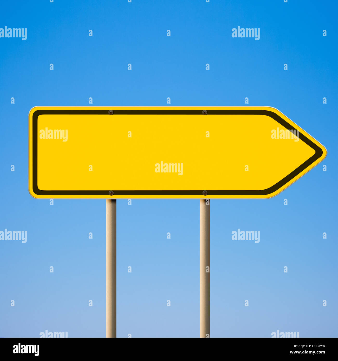 Blank yellow road sign, direction pointer to right against blue sky Stock Photo