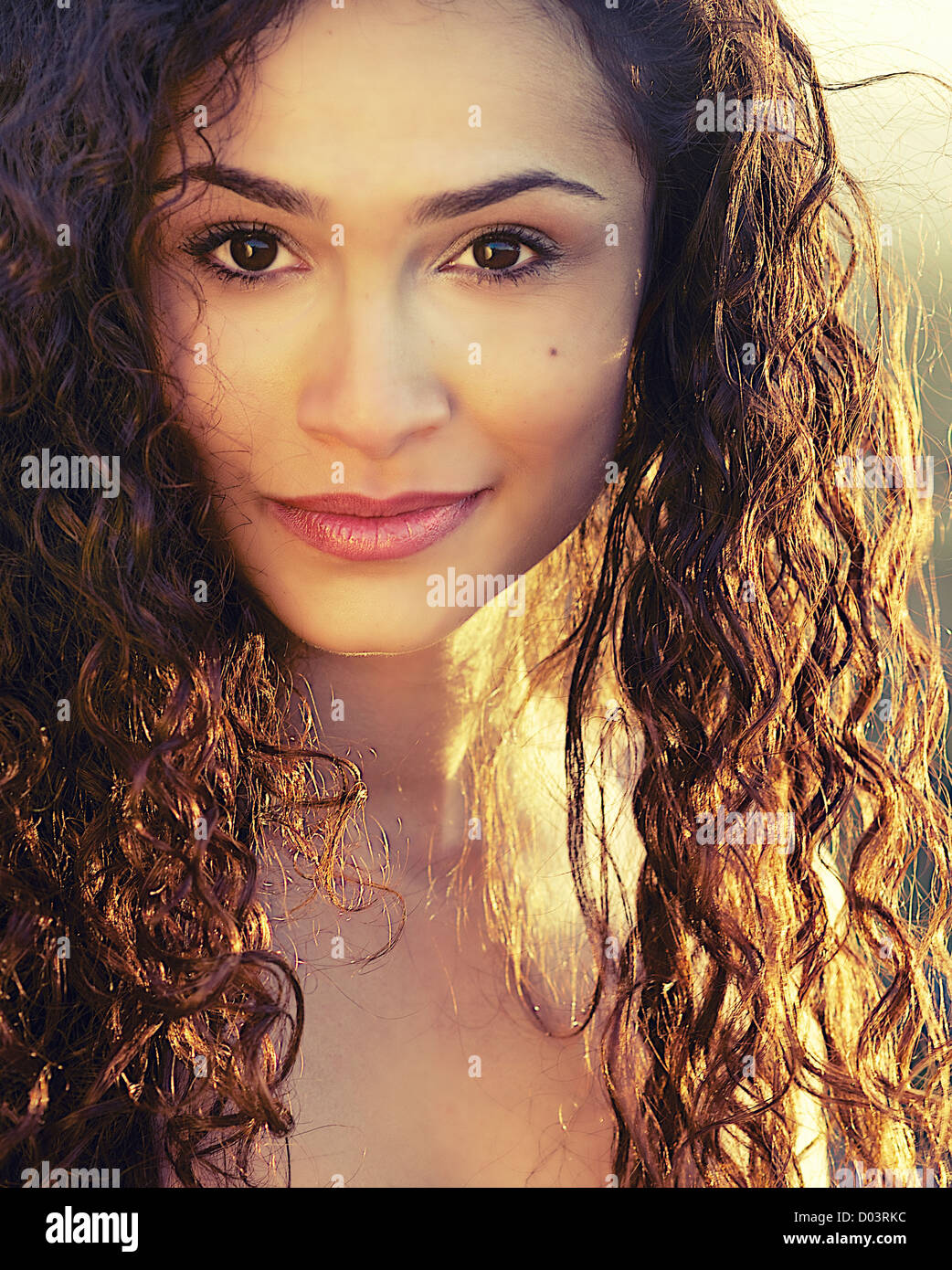 Beautiful young woman with curly hair and happy smile Stock Photo - Alamy