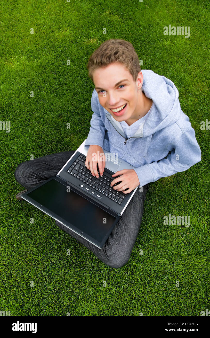 A young man with laptop computer outdoors Stock Photo