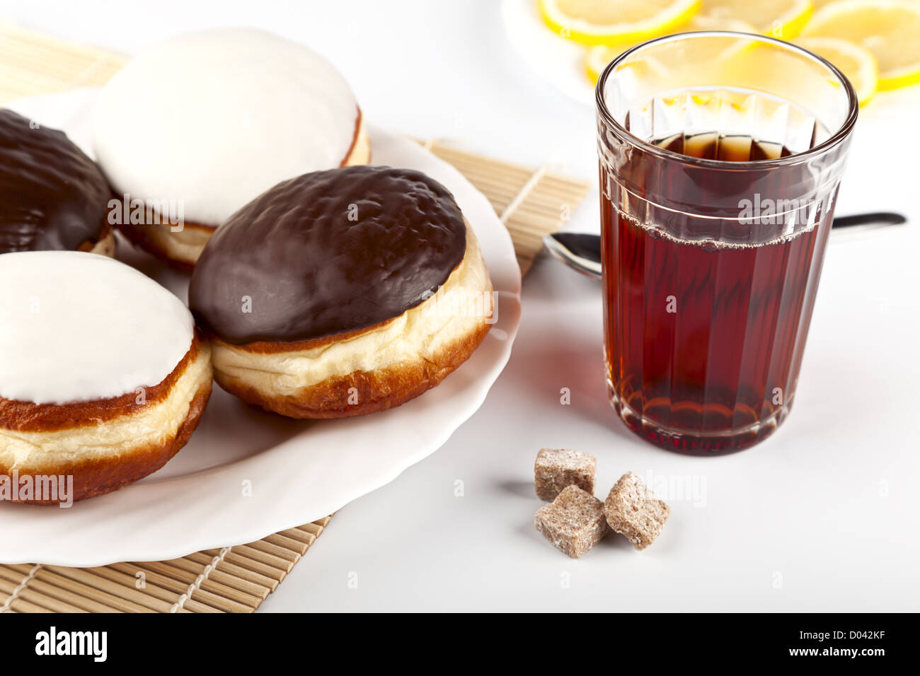 A cup of hot black tea and a plate of donuts Stock Photo