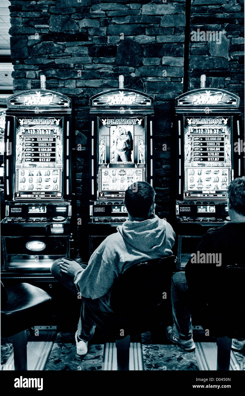 Men sit at slot machines in Foxwoods Resort Casino, Ledyard, Connecticut, USA Stock Photo
