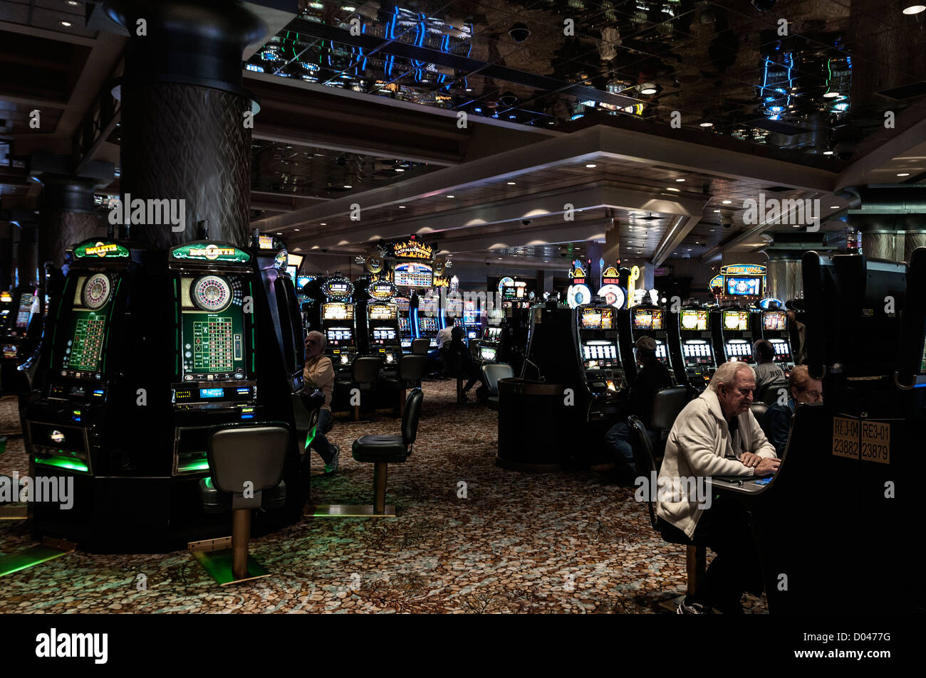 Men sit gambling at slot machines, Foxwoods Resort Casino interior, Ledyard, Connecticut, USA Stock Photo