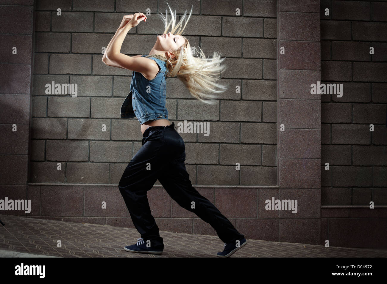 Teenage girl dancing hip-hop over the street wall Stock Photo
