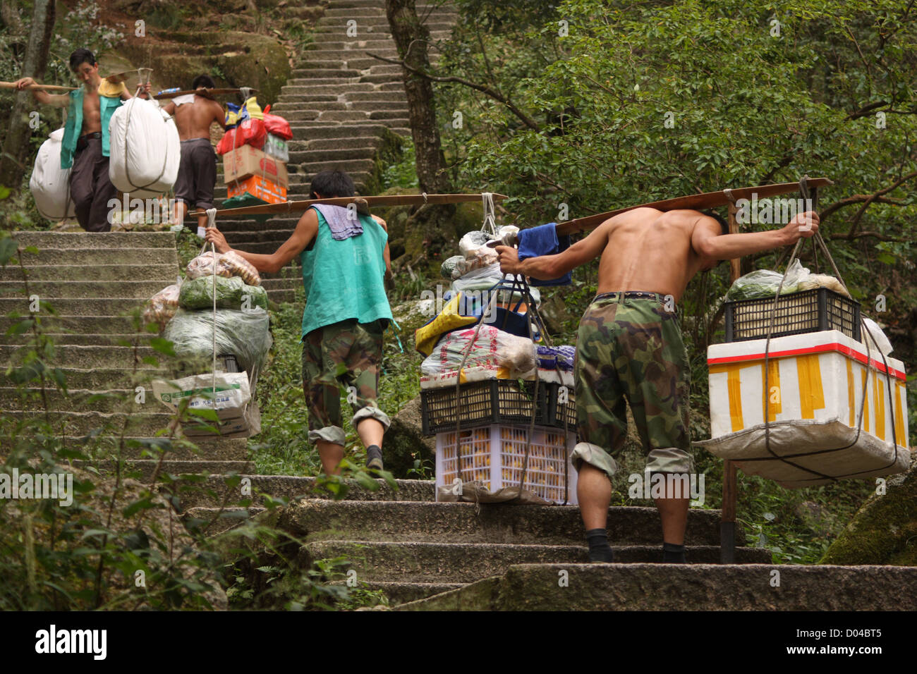 Porters carrying goods up the steps of Huang Shan (Yellow Mountain) Stock Photo
