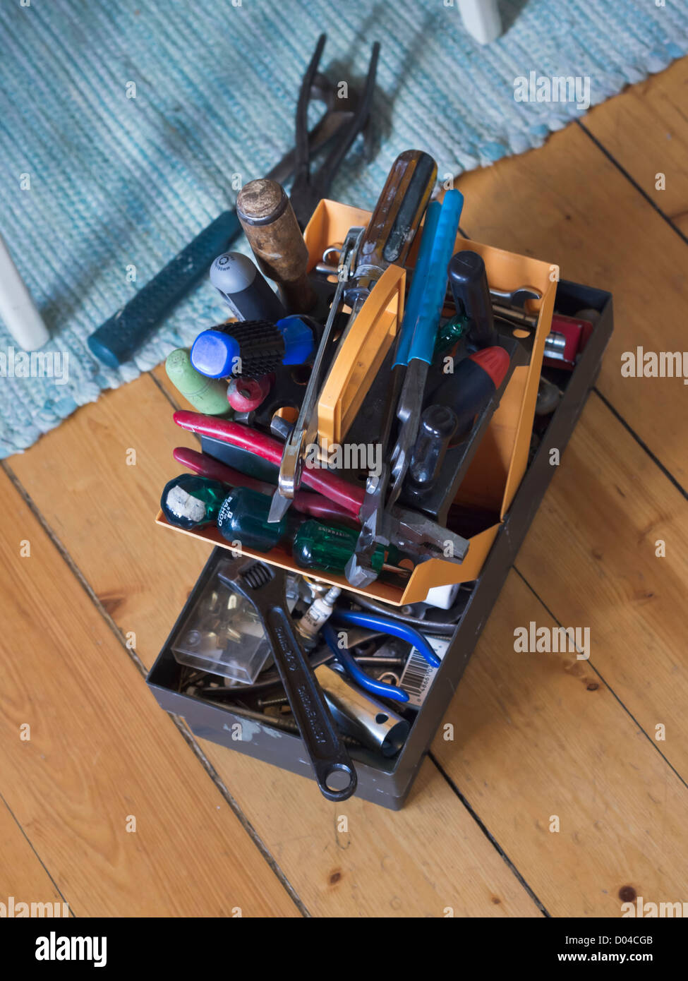 A toolbox on a wooden floor full of tools. Stock Photo