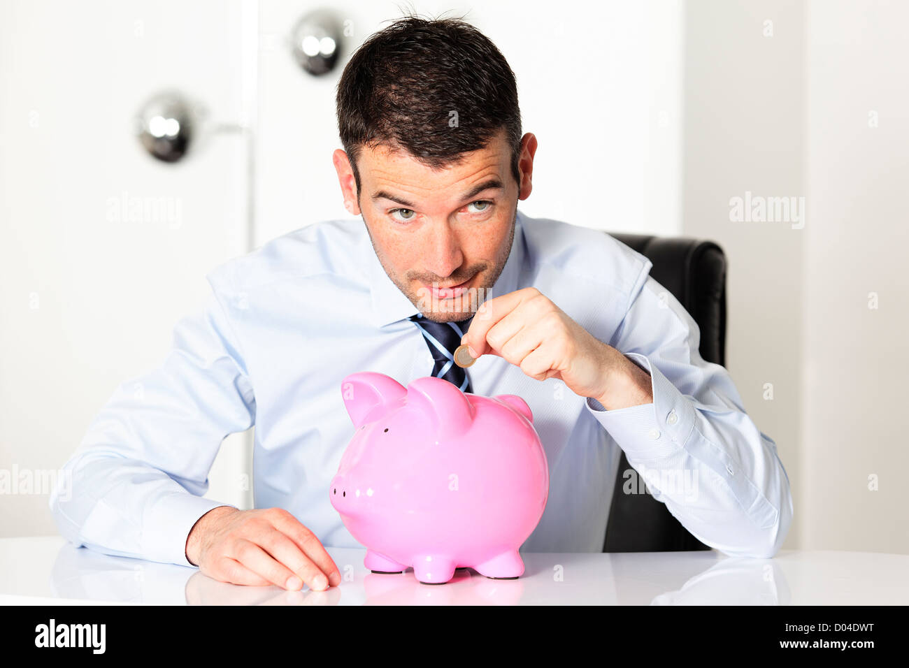 young man with pink piggy bank and coin Stock Photo - Alamy