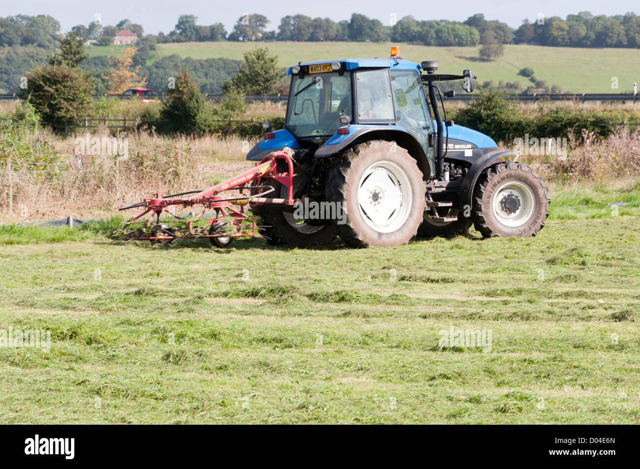 Tractor cutting grass to make hay Stock Photo Alamy