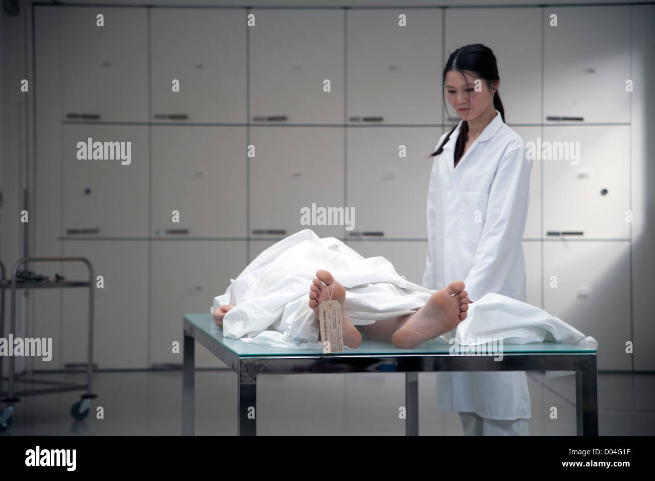 dead body on morgue table with pathologist Stock Photo