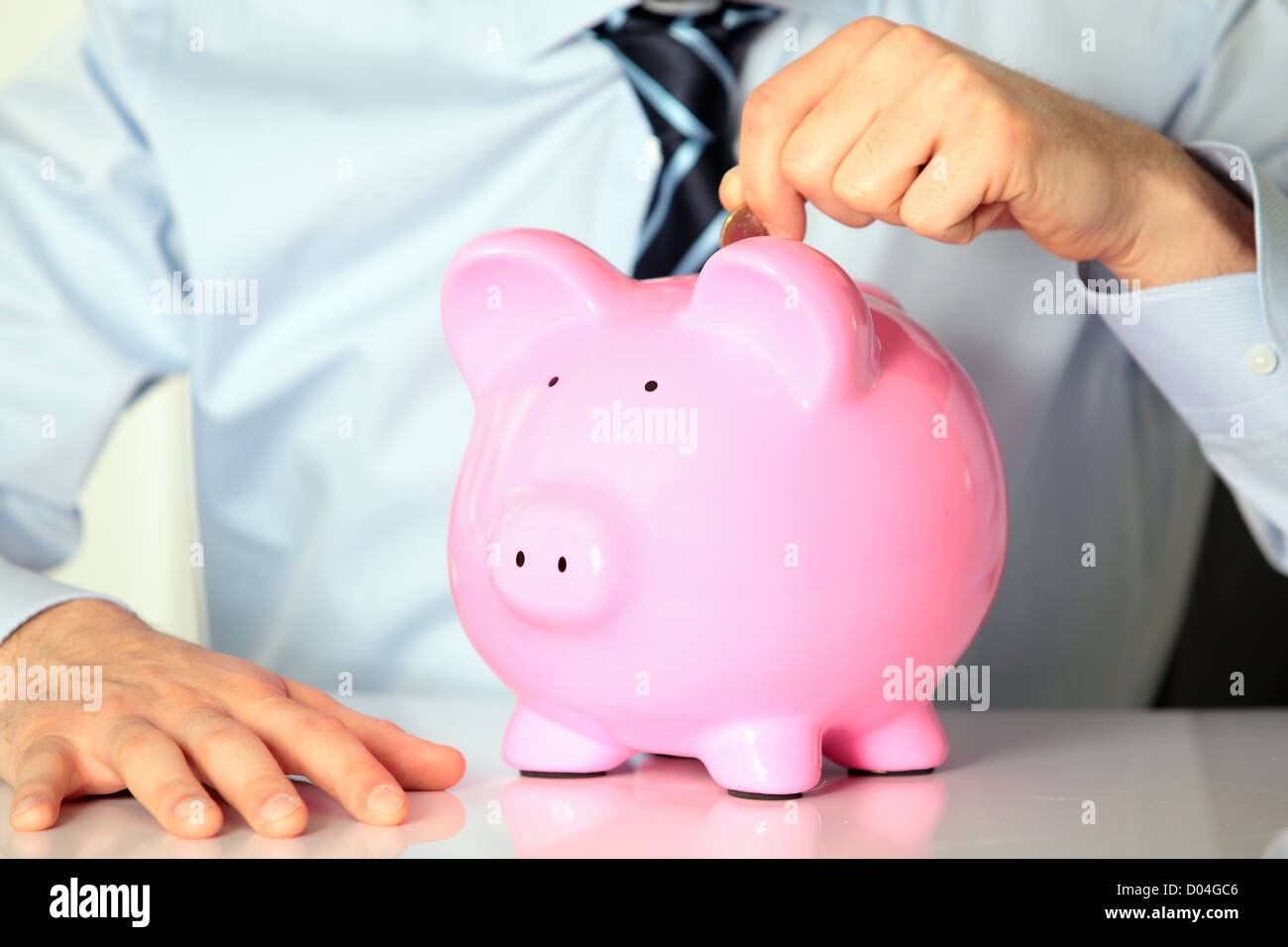 young man with pink piggy bank and coin Stock Photo - Alamy