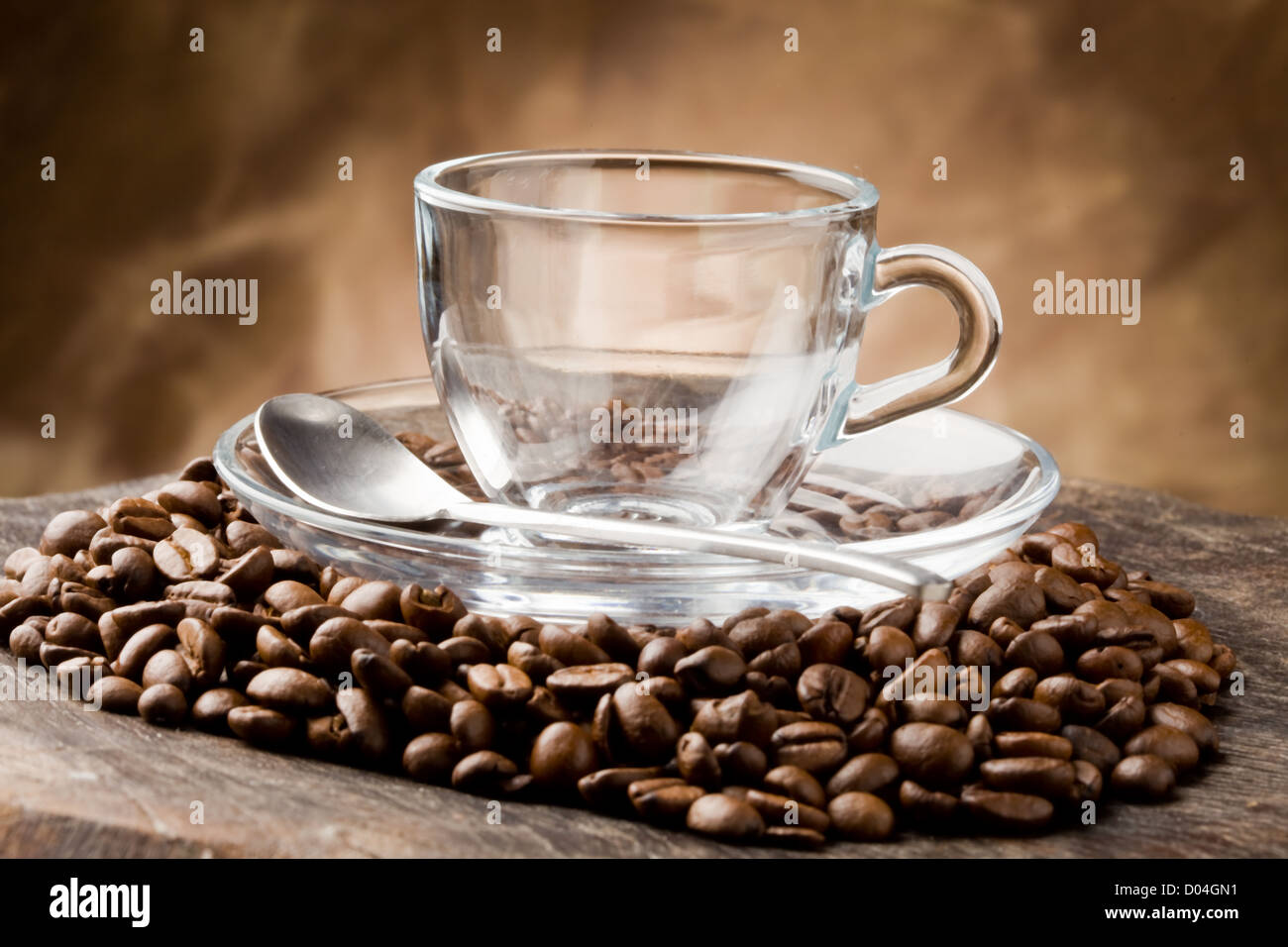 photo of empty glass cup on coffee beans over wooden table Stock Photo