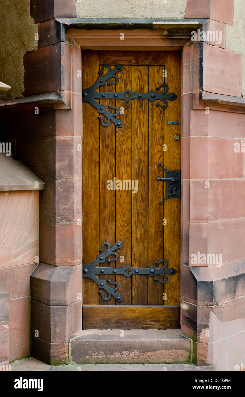Wooden door with wrought iron hardware Stock Photo - Alamy
