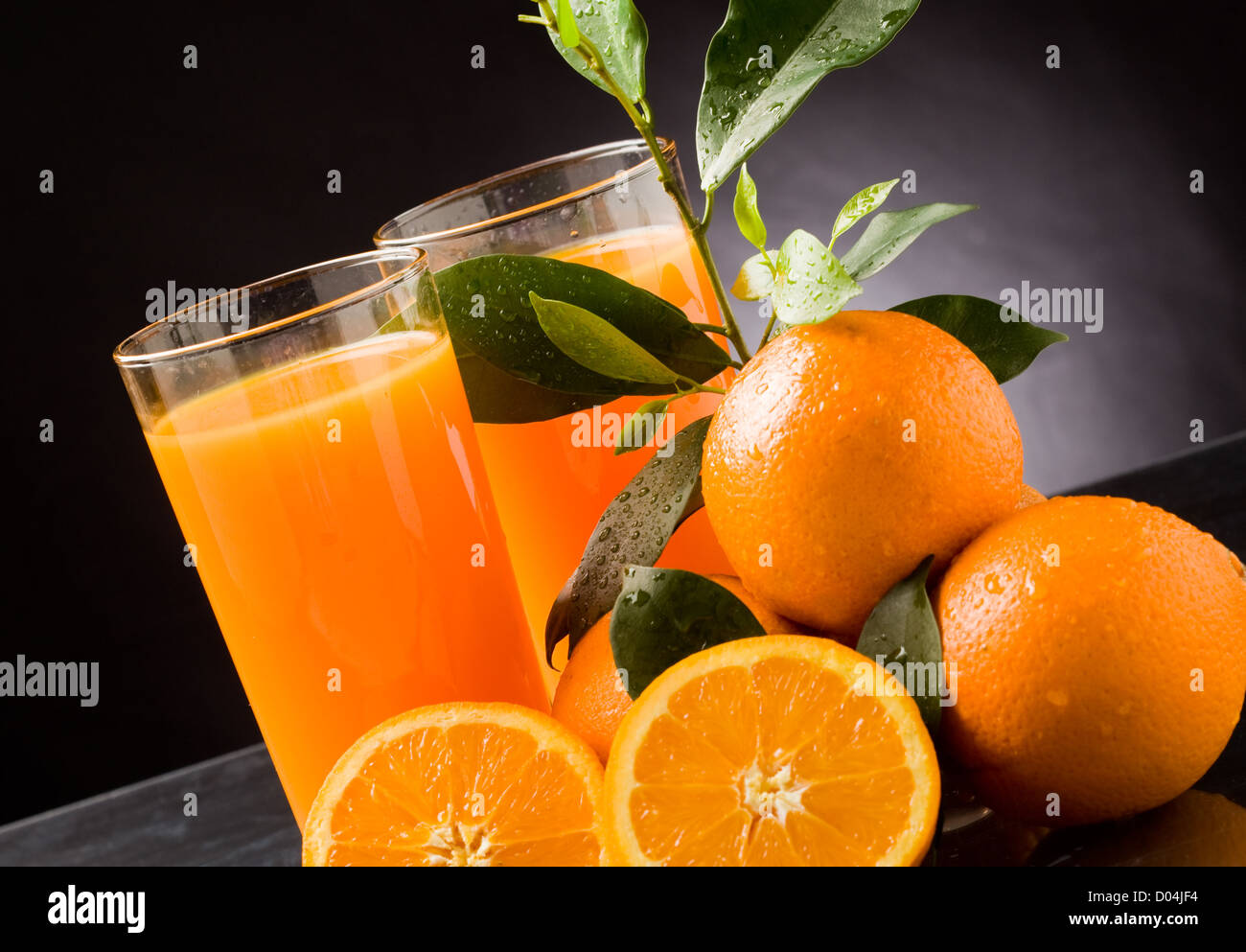 photo of fresh orange juice with water drops and green leaves Stock