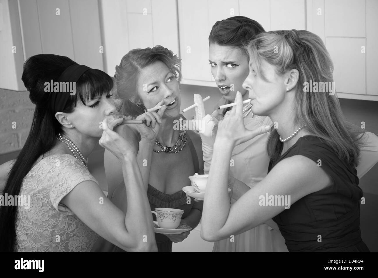 Unsure young woman around older ladies smoking in the kitchen Stock Photo