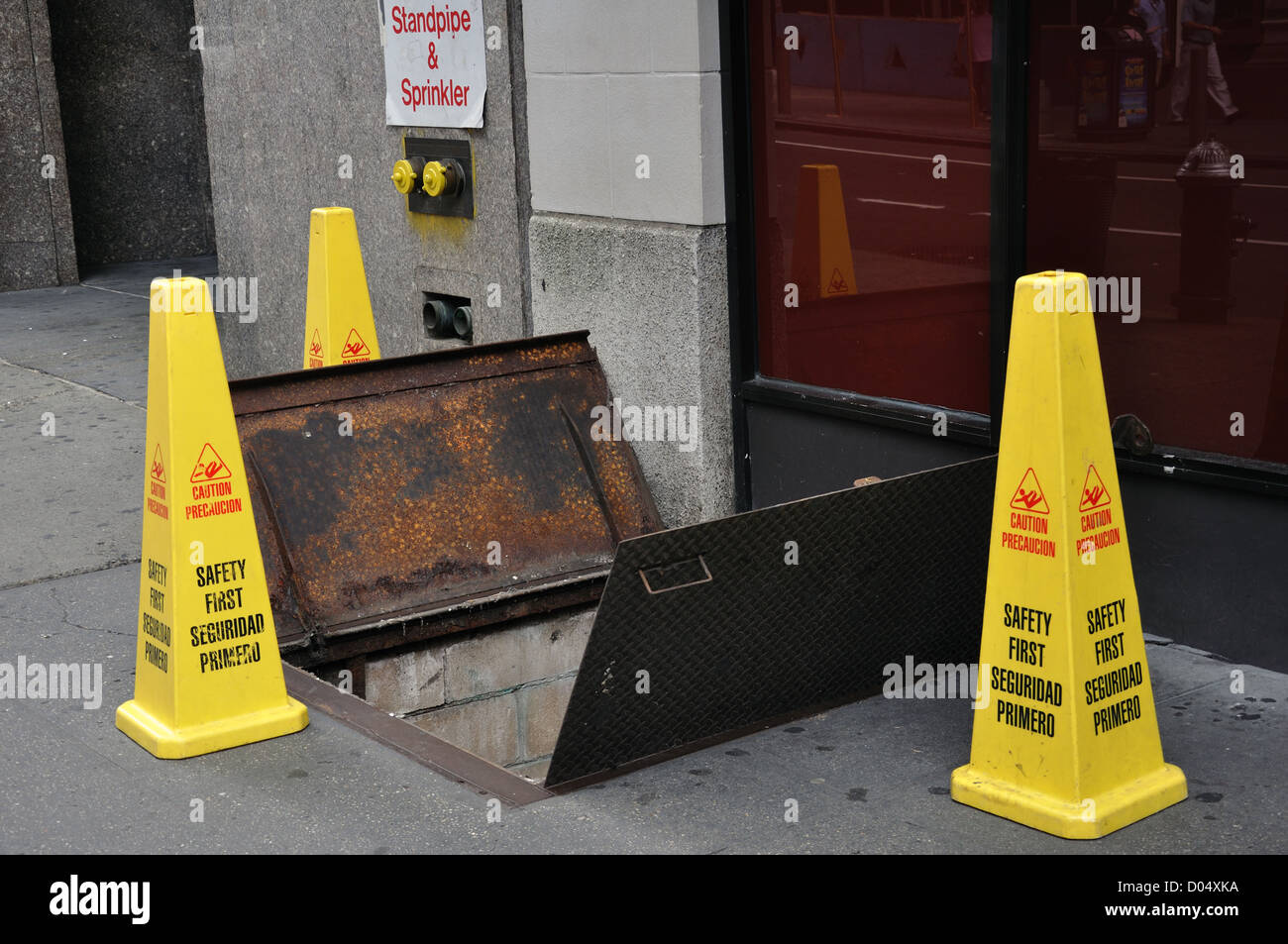 Open hatchway and warning cones, New York, USA Stock Photo