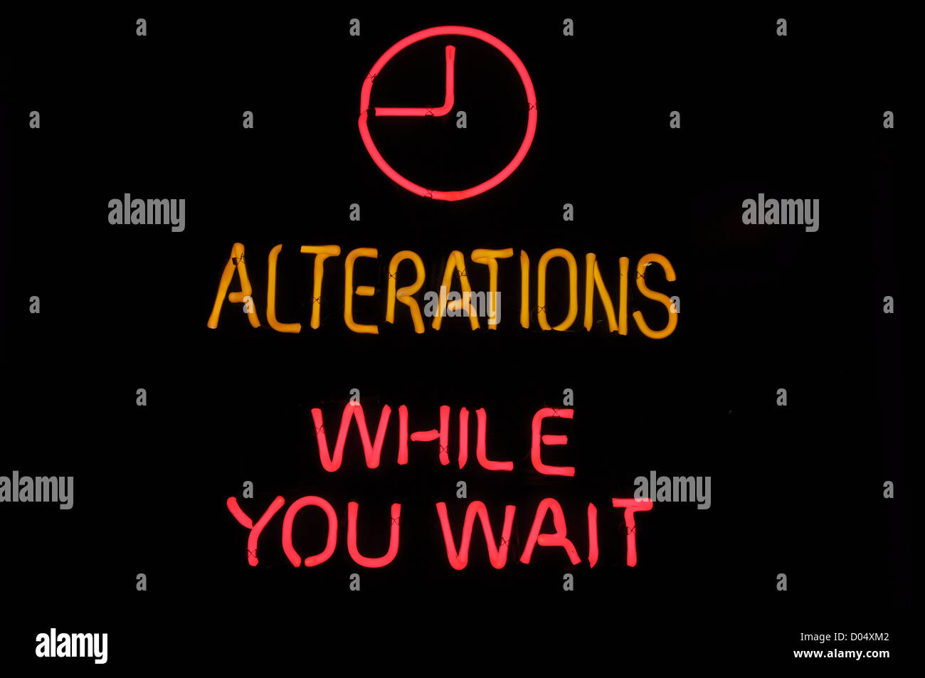 Alterations While You Wait Pink Neon Sign Stock Photo