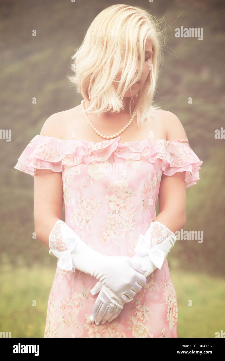 a woman in a dress standing on a meadow Stock Photo - Alamy