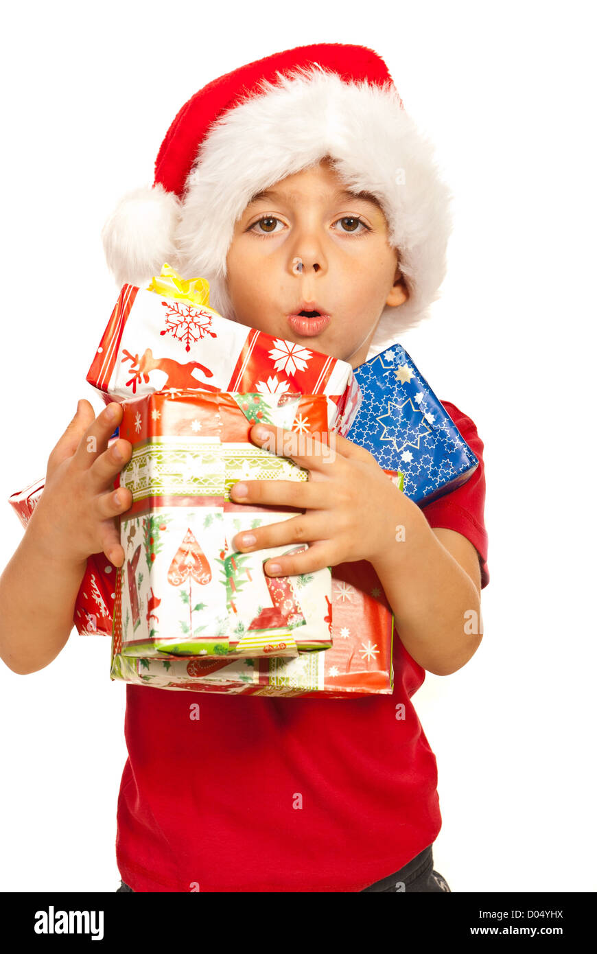 Little kid boy with santa hat holding many Christmas gifts in his arms