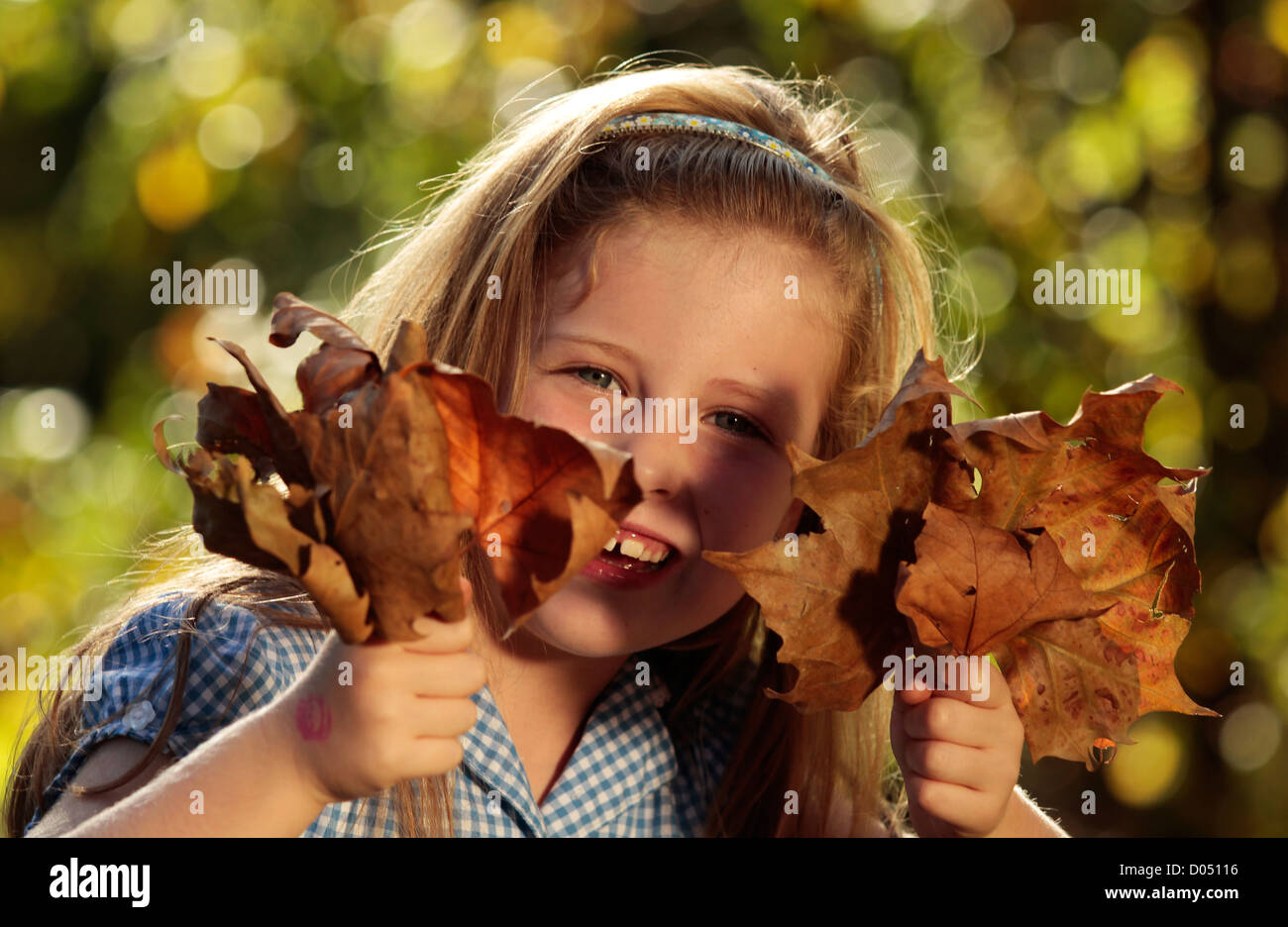 Young girl in a park with Autumn leaves Stock Photo - Alamy