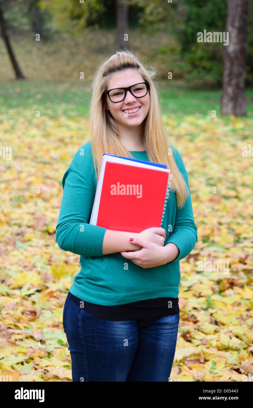 Portrait of smiling student girl holding books Stock Photo - Alamy