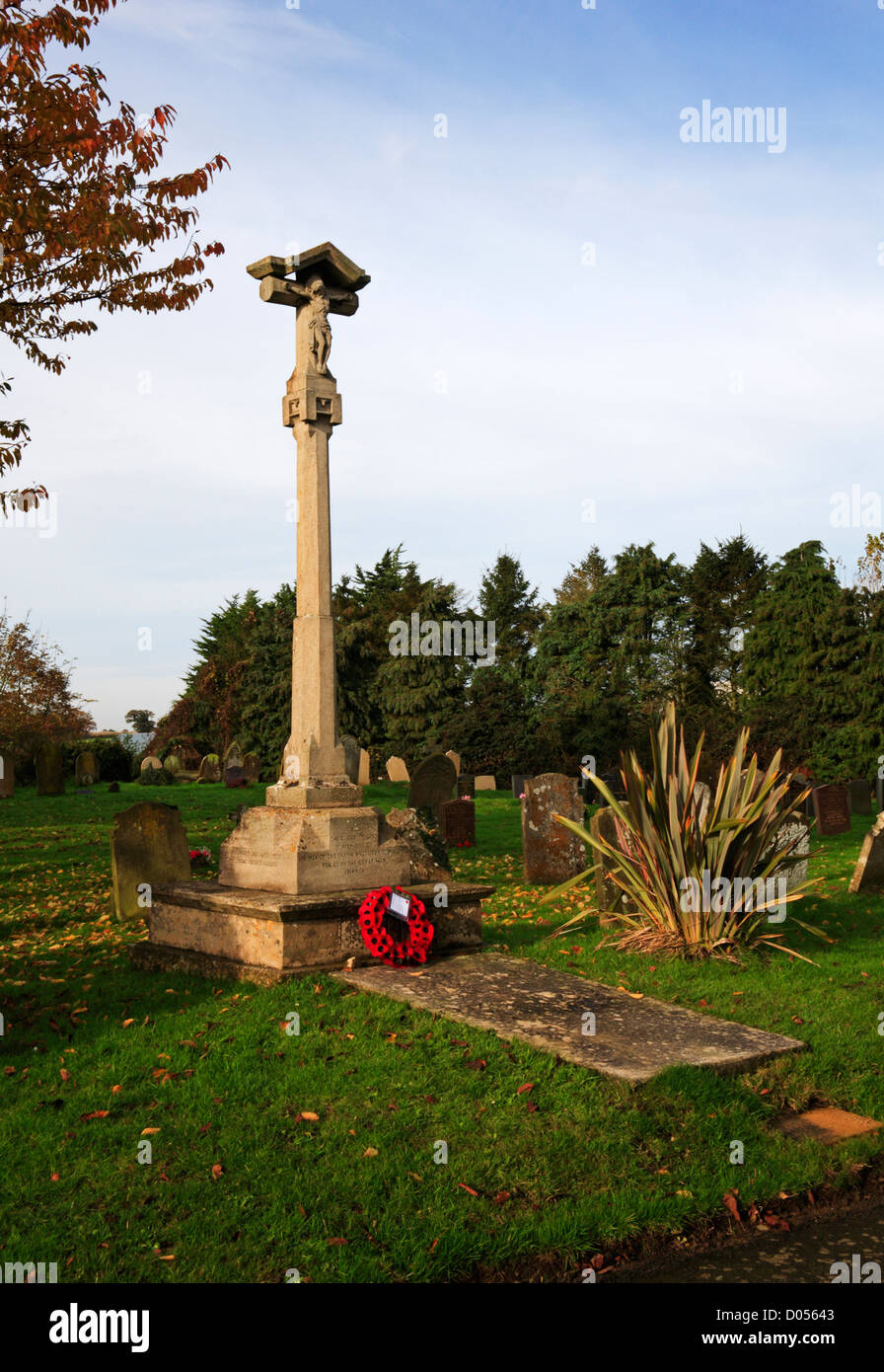 A war memorial with poppy wreath in the churchyard of the village of Mautby, Norfolk, England, United Kingdom. Stock Photo