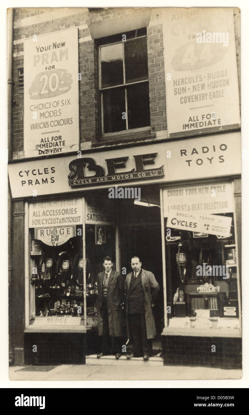 Shop keepers owner or staff /assistant/ assistants outside Bee Cycle and Motor Co., Liverpool, bikes  displayed in the shop fronts window,  UK early 1930's Stock Photo