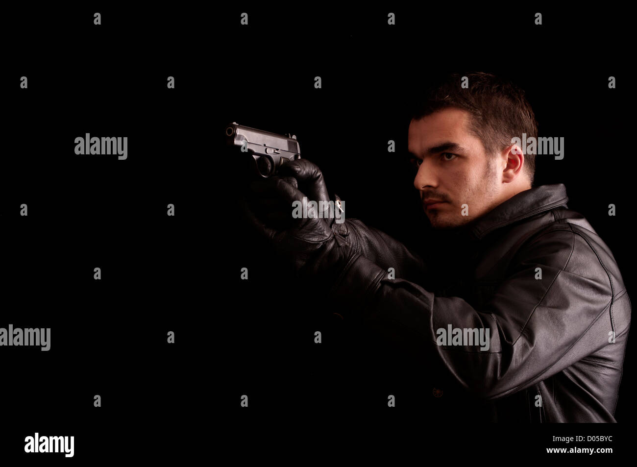 Young man holding a gun Stock Photo - Alamy