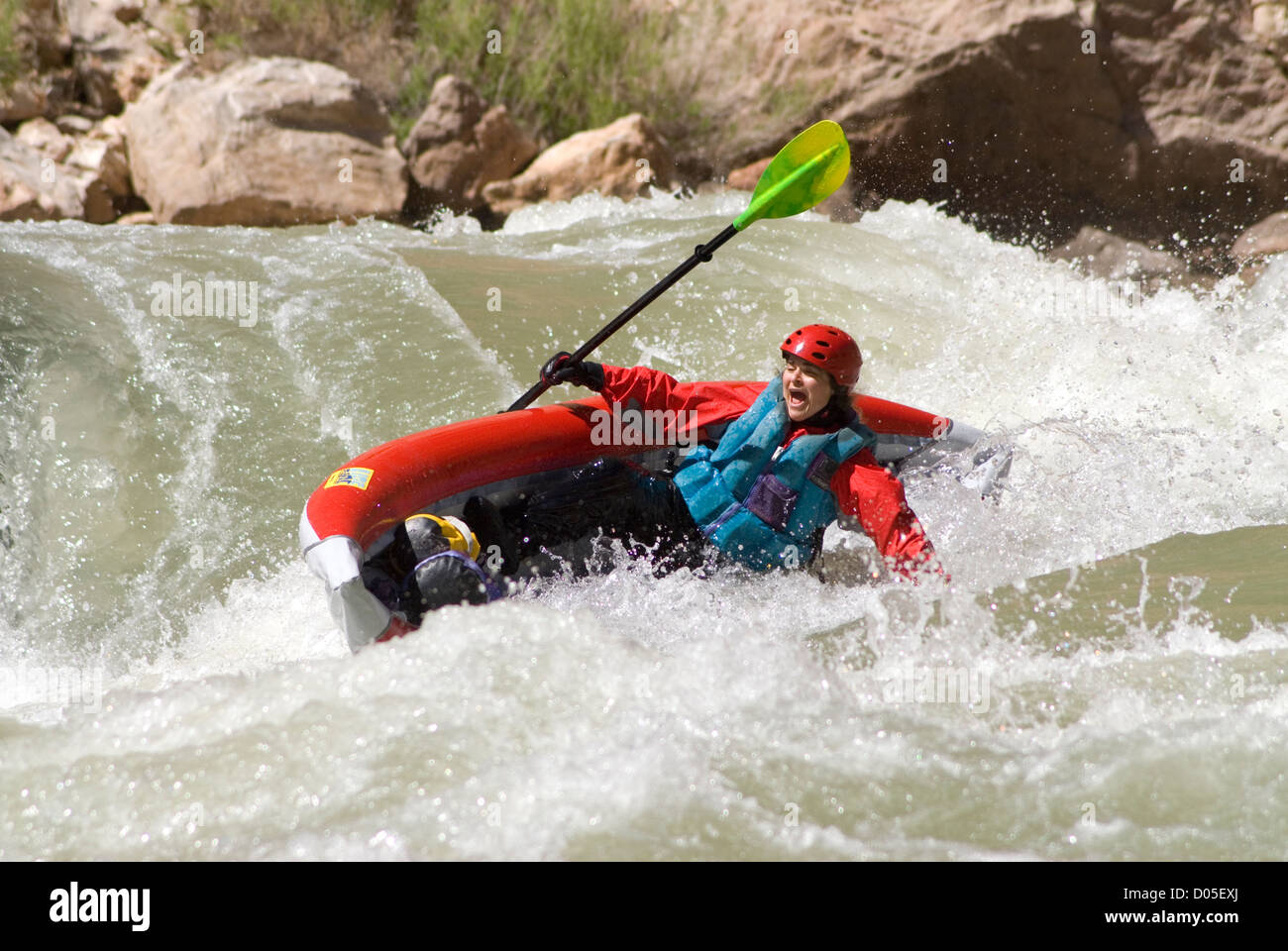 Woman paddling an inflatable kayak that's on it's way towards flipping
