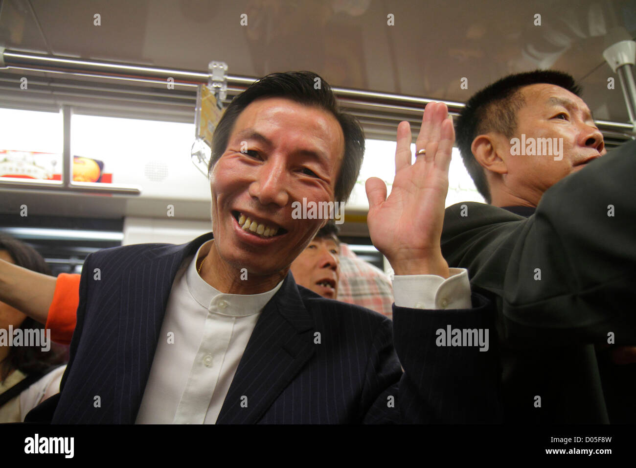 Shanghai China,Chinese Metro,subway,train,train,riders,Asian man men male adult adults,Green Line 2,smiling,happy,waving,drunk,man men male,China12100 Stock Photo