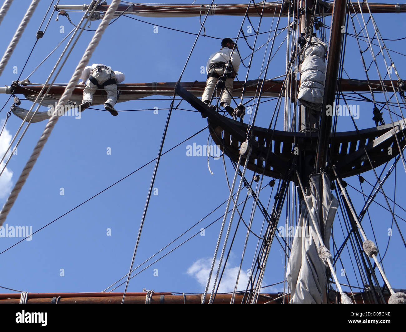 Crew unfurls a sail on a yardarm of a tallship near Kirkland, Washington  Stock Photo