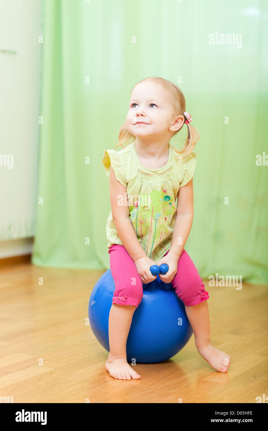 Toddler girl jumping on ball Stock Photo Alamy