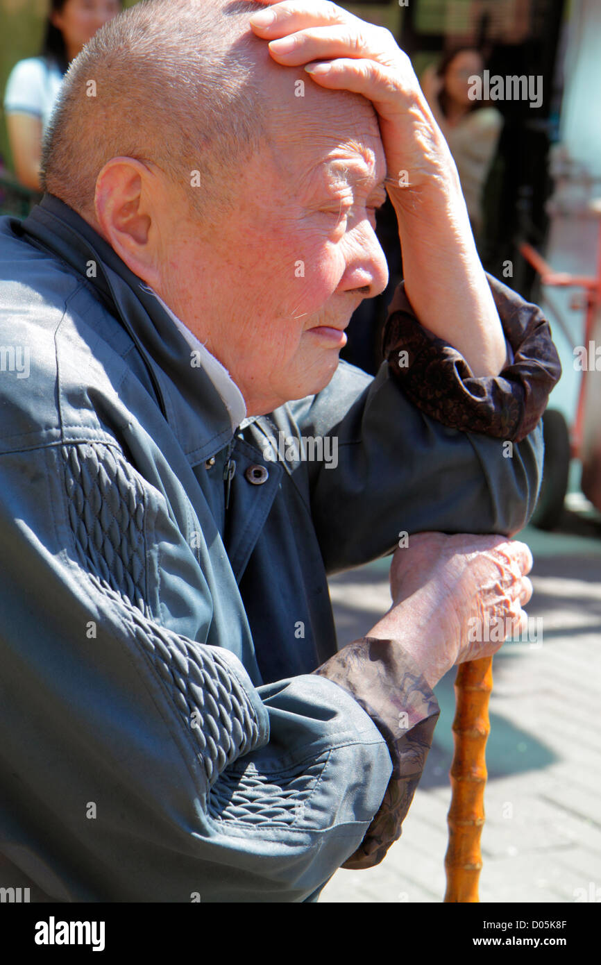 Shanghai China,Chinese Huangpu District,Jiangxi Road,Asian man men male adult adults,senior seniors citizen citizens,cane,resting,hand on head,retired Stock Photo