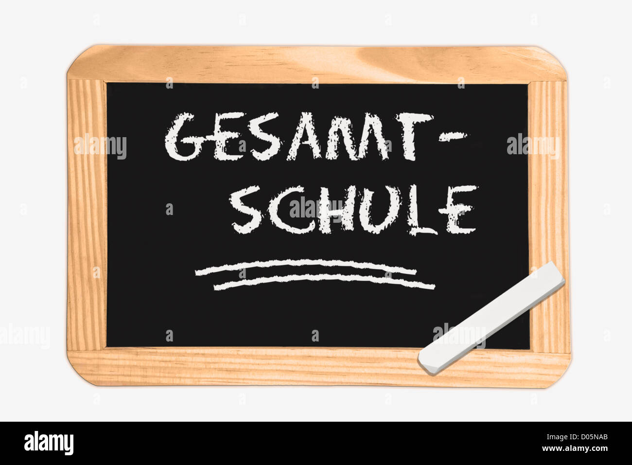 Detail photo of a Chalkboard with the German inscription comprehensive school, white chalk lies in a corner Stock Photo