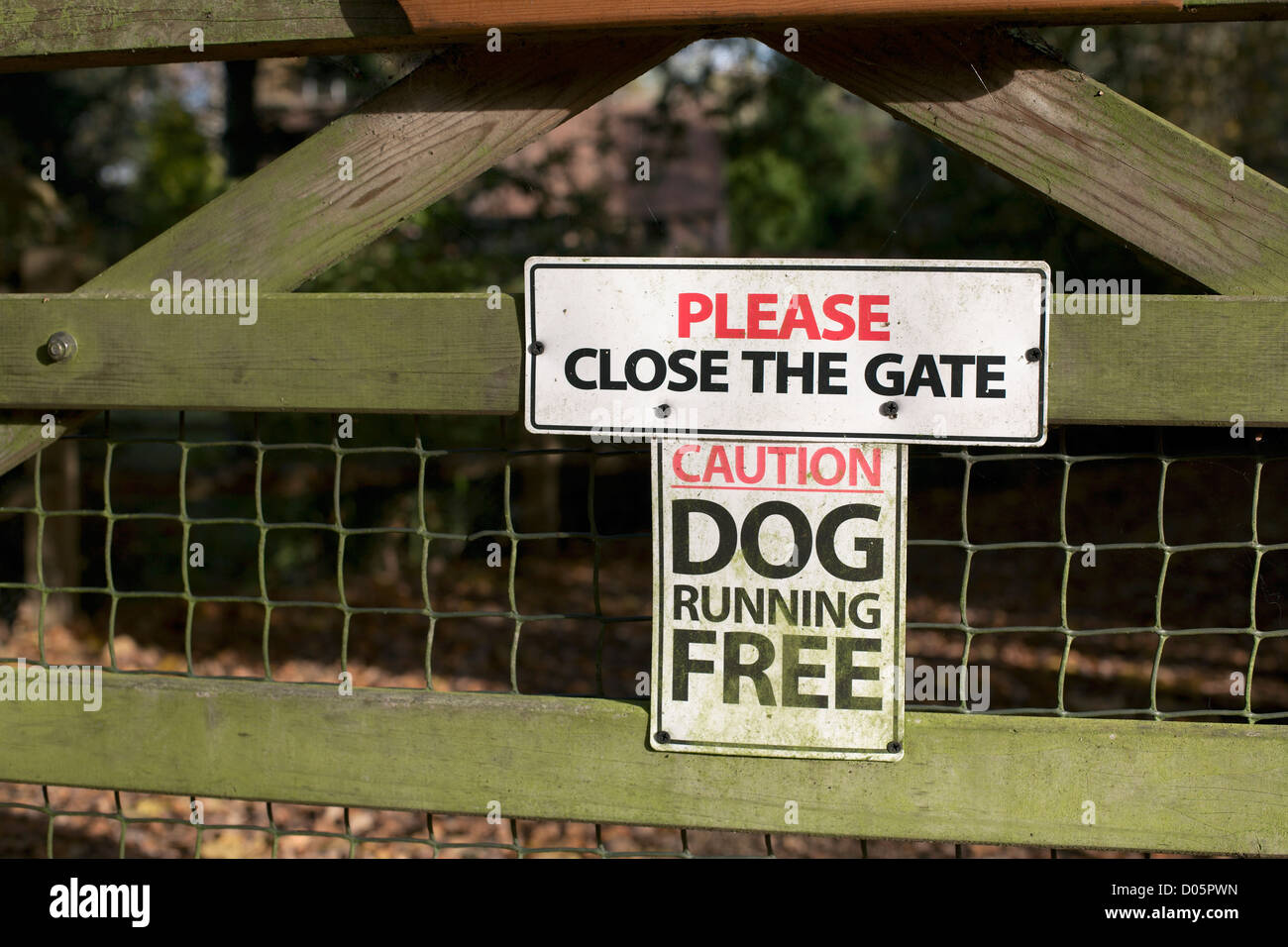 Sign on house gate please close the gate caution dog running free Stock Photo