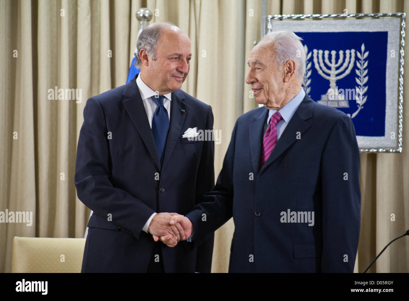 Israeli President Shimon Peres and French Foreign Minister Laurent Fabius shake hands at the opening of a joint meeting. Jerusalem, Israel. 18-Nov-2012.  Israeli President Shimon Peres meets French Foreign Minister Laurent Fabius who is visiting the region for meetings with the leaders of Israel and the Palestinian Authority in light of warfare in Gaza. Stock Photo