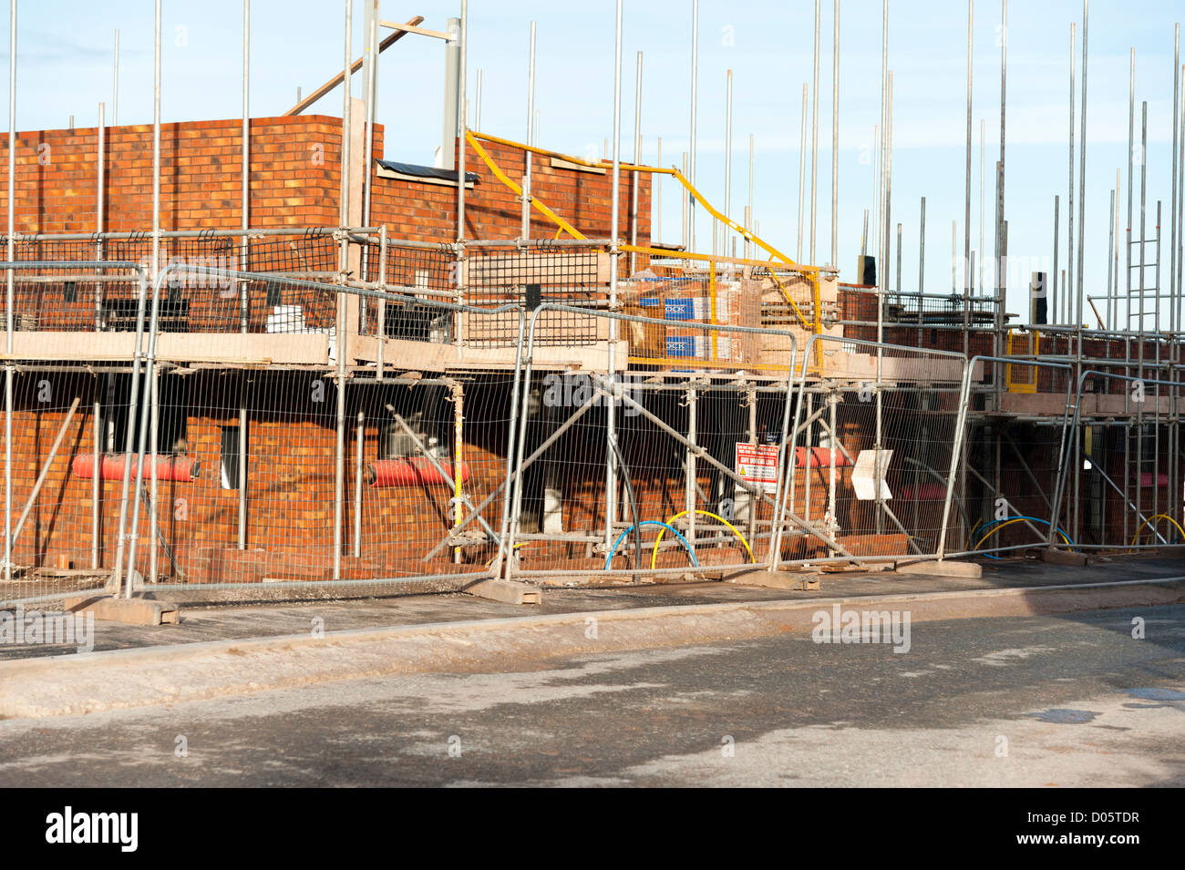 Building site for a new housing estate, UK. Scaffolding around a new house build. Stock Photo