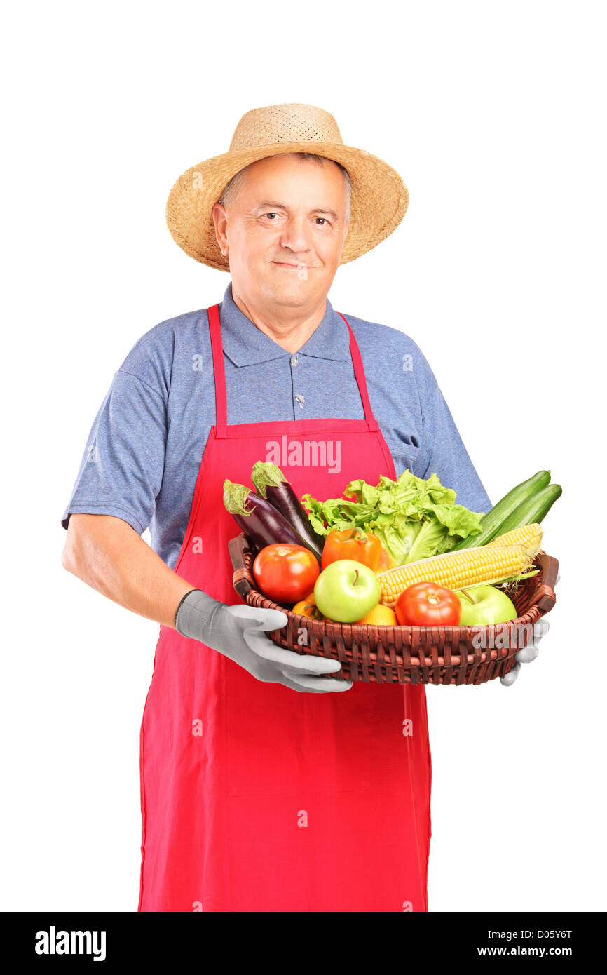 Mature farmer man holding a basket with fresh vegetables isolated on ...