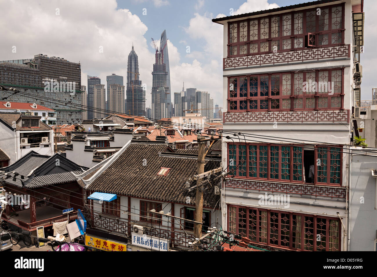 Traditional chinese tile roofs contrast the modern skyline of Shanghai, China Stock Photo