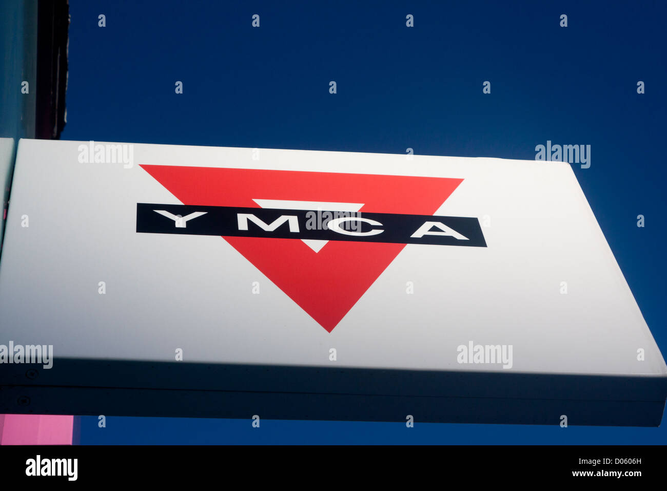 YMCA charity shop sign with distinctive red triangle on blue sky background Cardiff Wales UK Stock Photo