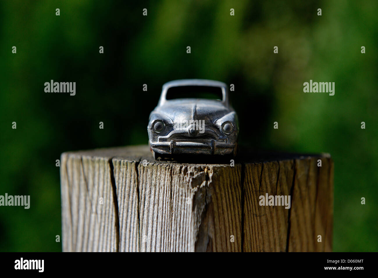 Toy Car. on a wooden garden post - Simca 9 Aronde 1951 24U MECCANO - Stripped of it's paintwork. Background blurred. . . Stock Photo