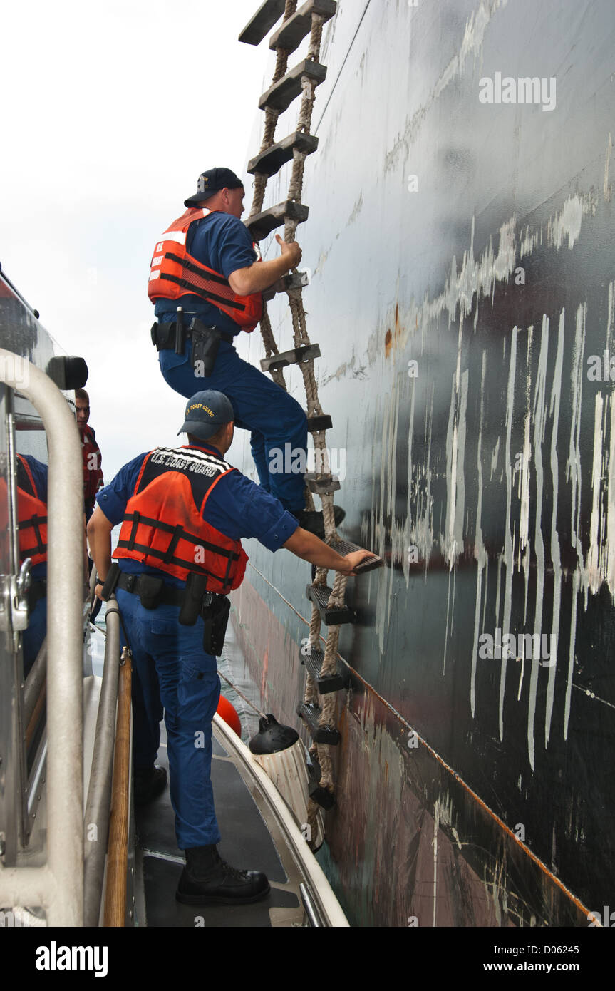 US Coast Guard agents climb rope ladder to board a tanker ship