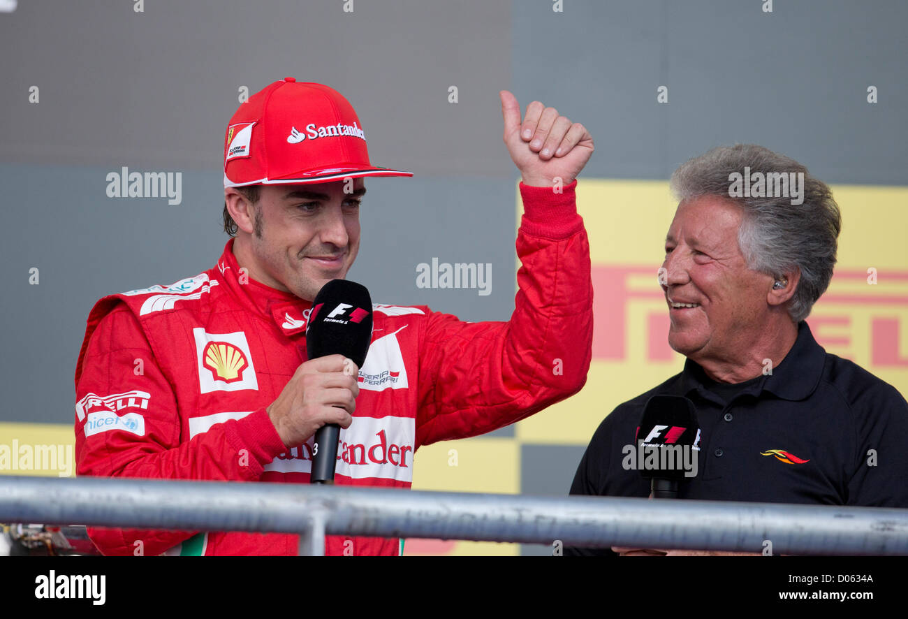 F1 driver Fernando Alonso (l) gives post-race comments as Mario Andretti watches at the United States Grand Prix in Austin TX Stock Photo