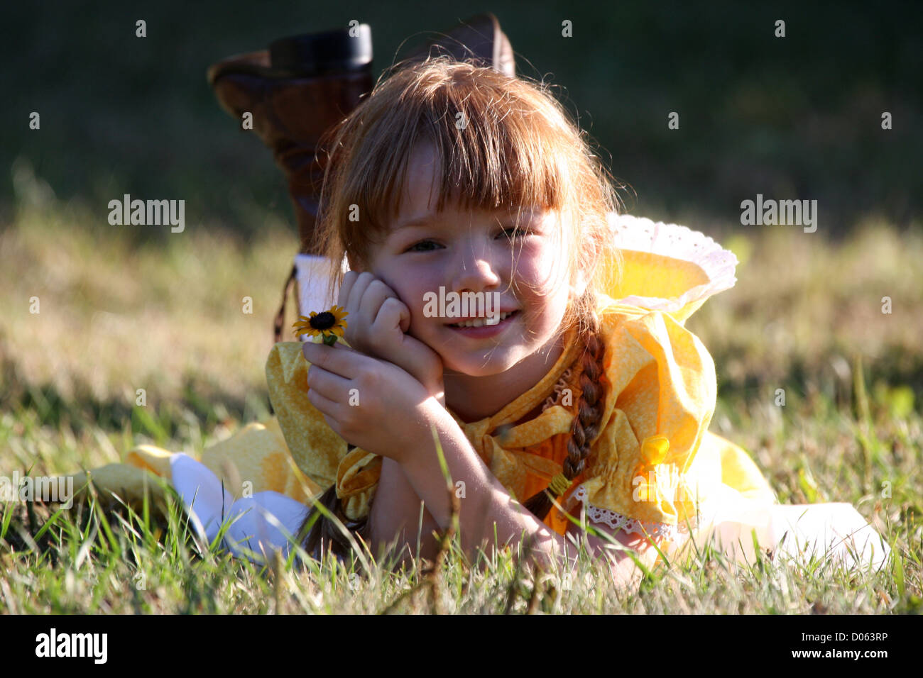 A young smiling girl holding a flower Stock Photo - Alamy