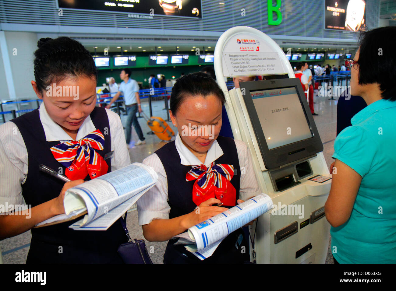 Shanghai China,Chinese Changning District,Hongqiao Airport,Terminal 2,SHA,self service check in kiosk,Asian woman female women,uniform,China Eastern A Stock Photo