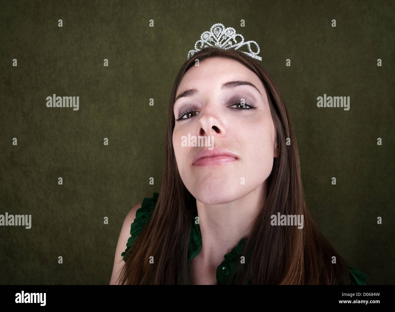 Proud woman with tiara on green background Stock Photo